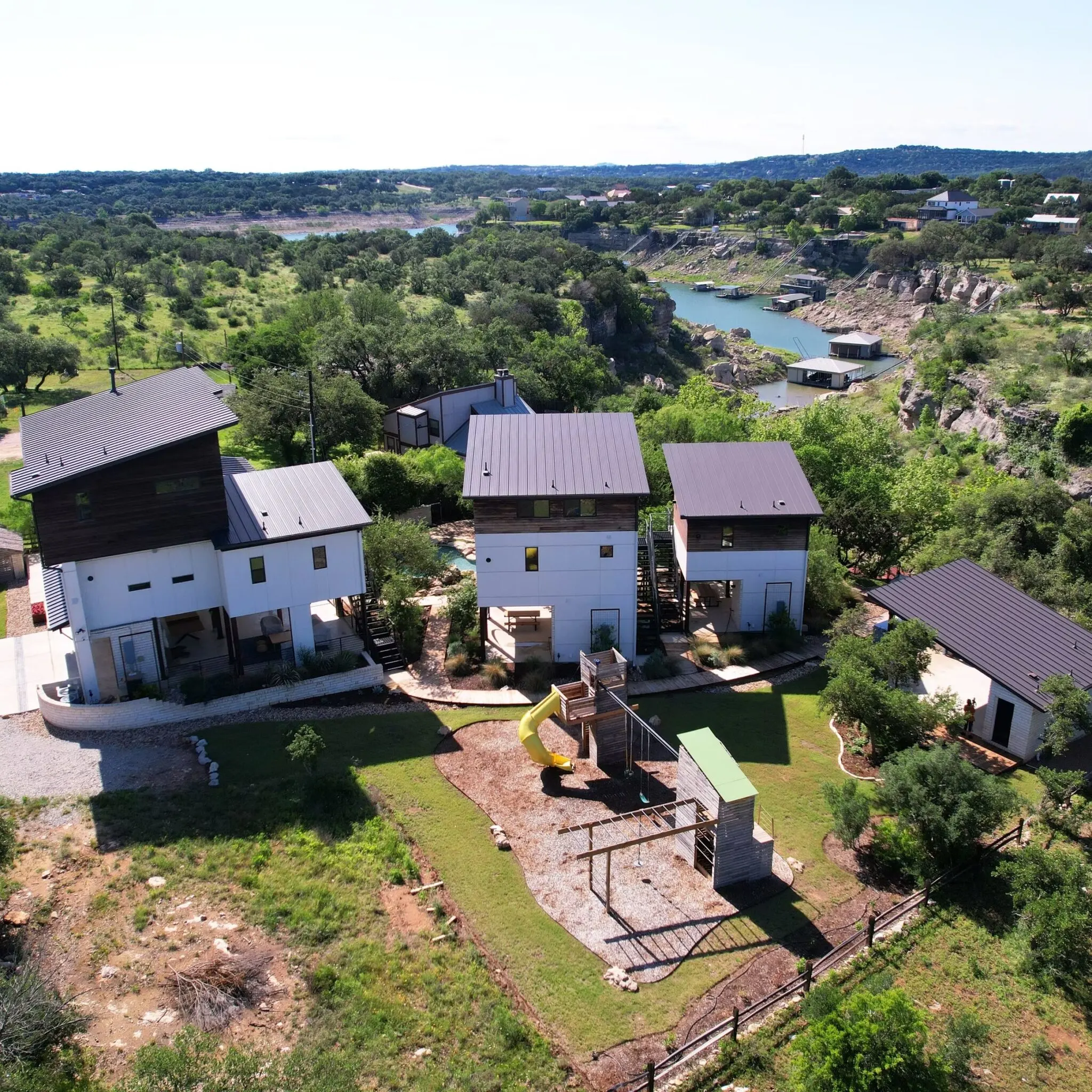 Finished cedar deck in Austin Texas with lush greenery, modern home, outdoor furniture, bright daylight, outdoor living