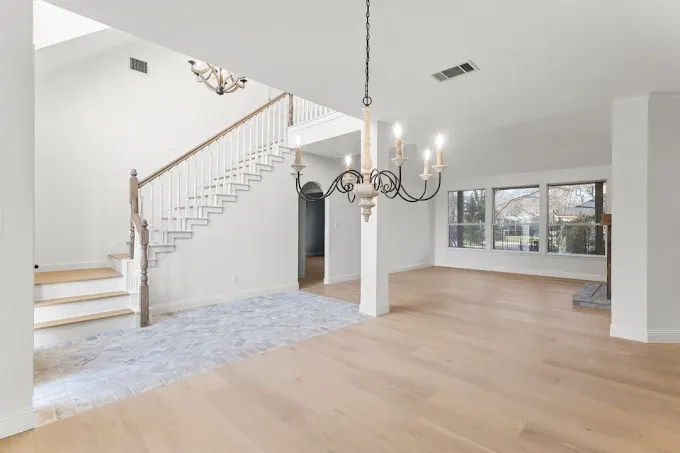 Remodeled Austin kitchen with granite countertops, stainless steel appliances, and custom cabinetry, featuring a marble island and pendant lights.