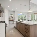 Refaced Austin kitchen with sleek wood grain cabinets, marble countertops, elegant tile backsplash, and polished hardwood flooring