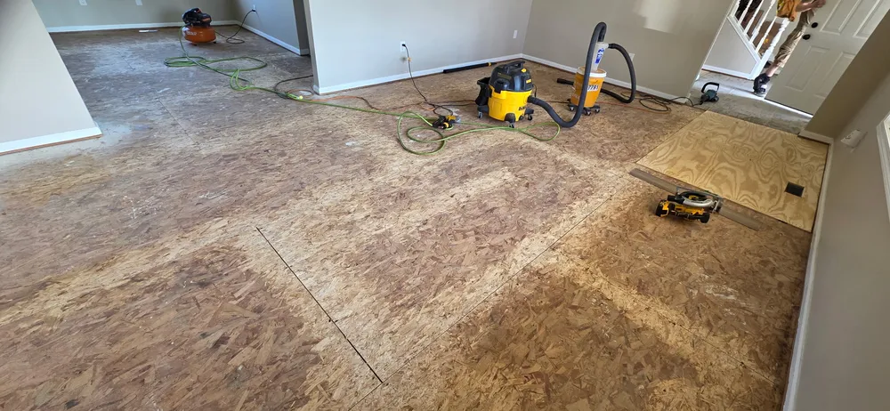 Completed wooden subfloor replacement in a spacious, well-lit room in Darien IL with soft wall colors and tools nearby.