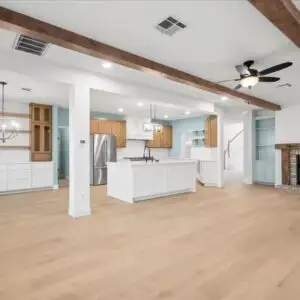Modern renovated living room in Austin TX with open design, large windows, hardwood floors, contemporary furniture, and seamless architecture