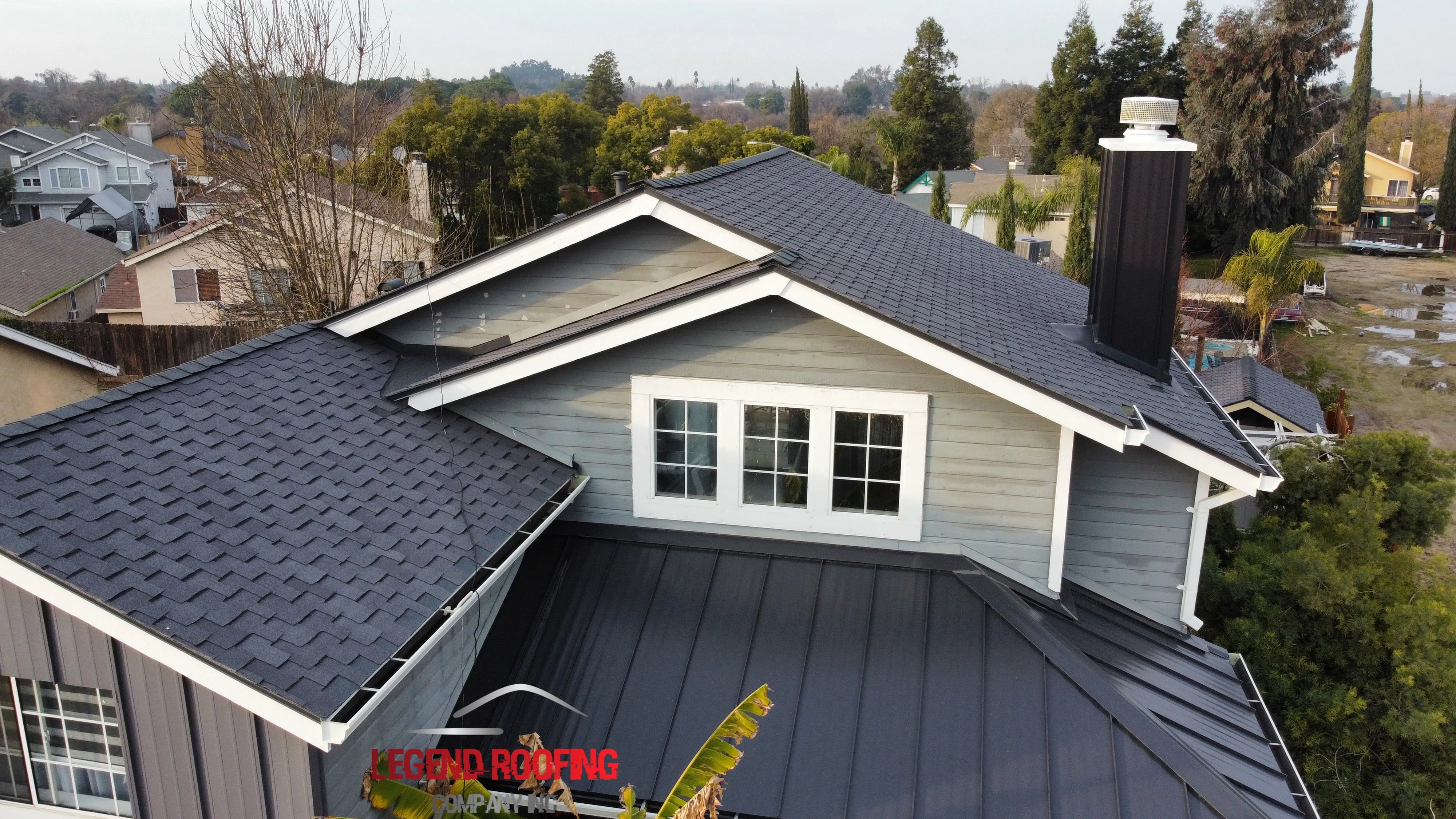 Newly installed asphalt shingle roof on modern home in Modesto with detailed textures, bright sky, lush landscaping, and nearby neighborhood