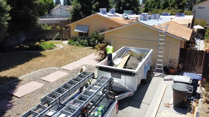 Freshly repaired roof with new shingles on a suburban home in Modesto CA amid lush greenery and a bright clear sky