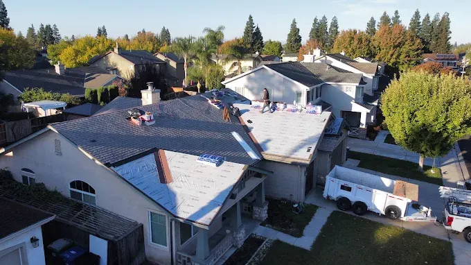 Freshly completed roof replacement in Modesto CA, featuring gray asphalt shingles and a well-maintained yard.