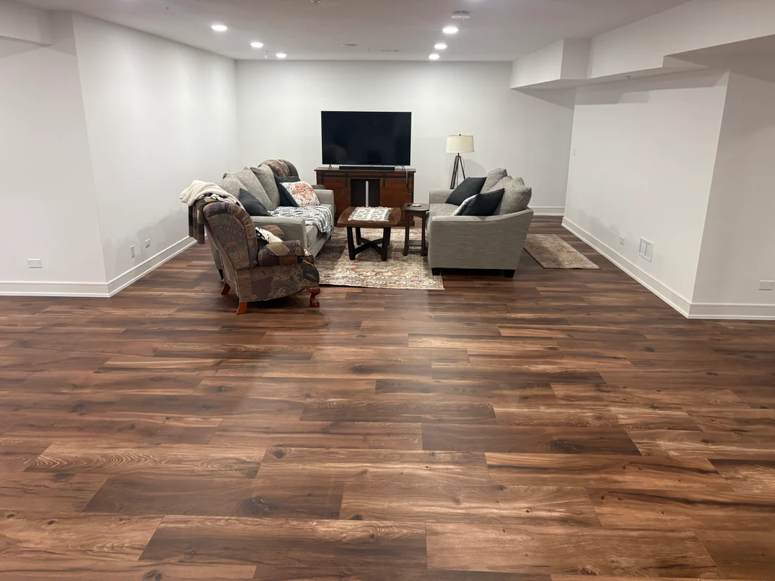 Completed baseboard installation in a modern living room in Darien IL with polished hardwood and elegant decor.
