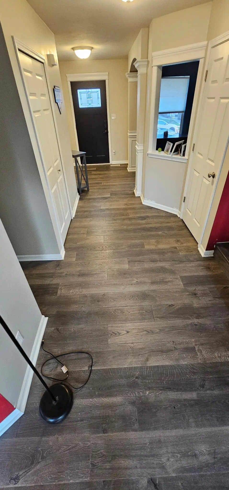Spacious room with polished hardwood flooring, large windows, white baseboards, and a stylish area rug in Darien IL.