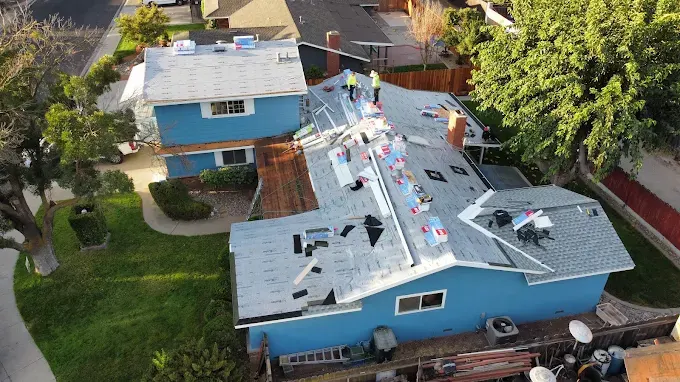 Recently replaced residential roof in Modesto CA with earthy asphalt shingles, lush yard, and clear sunny sky