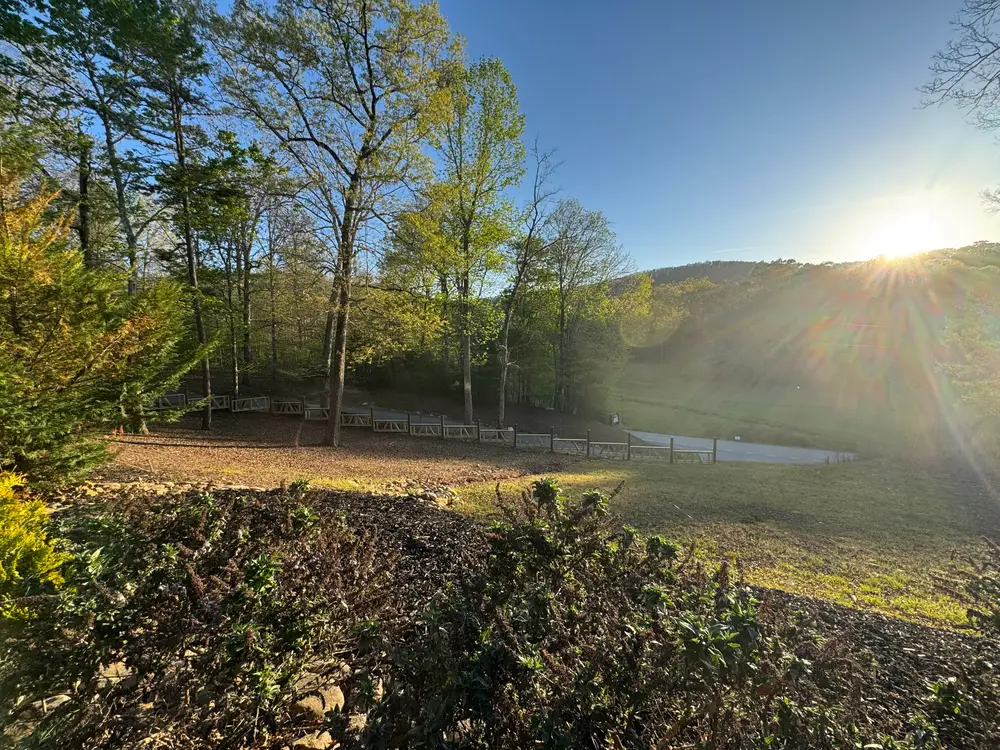 Completed wooden fence installation in Cohutta GA, showcasing craftsmanship amidst lush pastures and rolling hills.