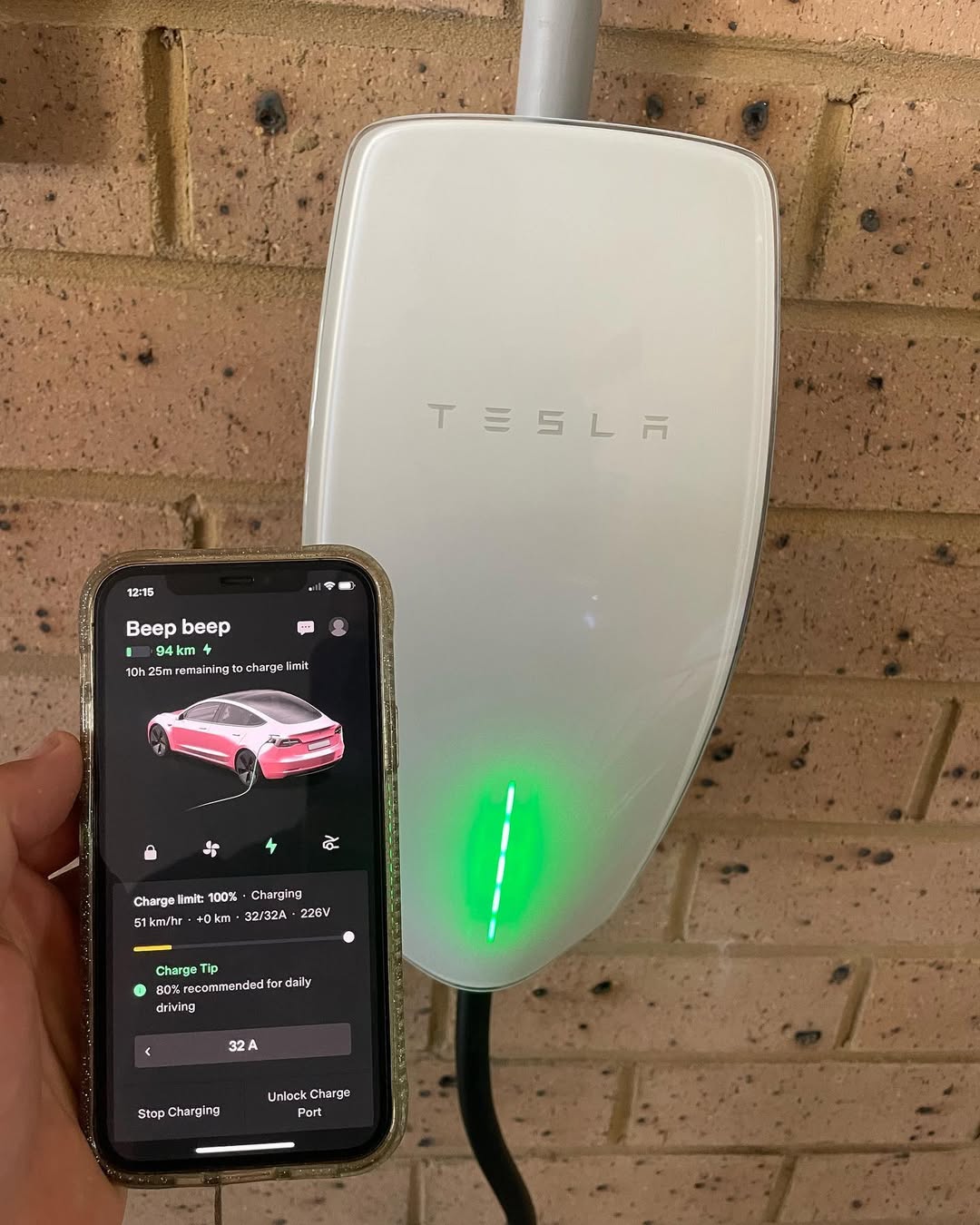 Tesla EV charger with phone app showing charge status