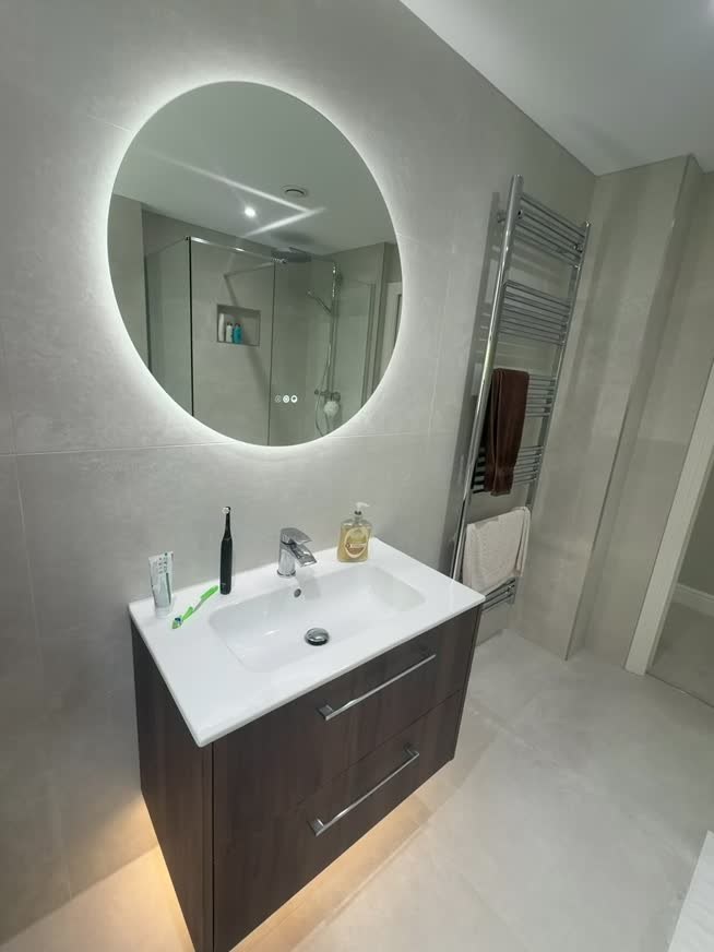 Completed master bathroom with walk-in shower and illuminated mirror at Solihull Road