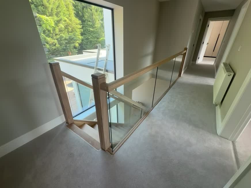 Glass landing balustrade with an oak handrail at the Solihull Road renovation