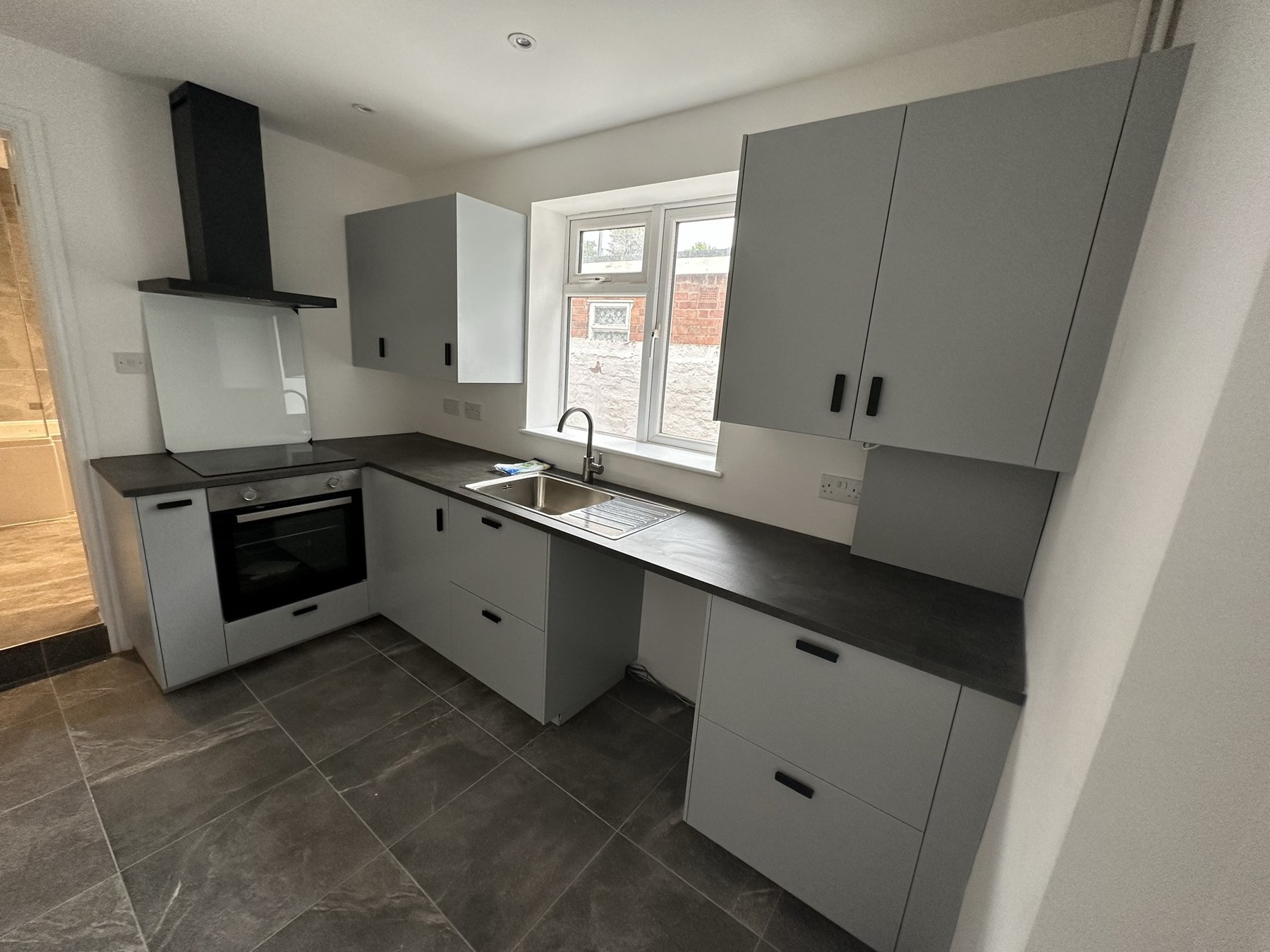 Completed grey landlord kitchen with black worktops in Halesowen