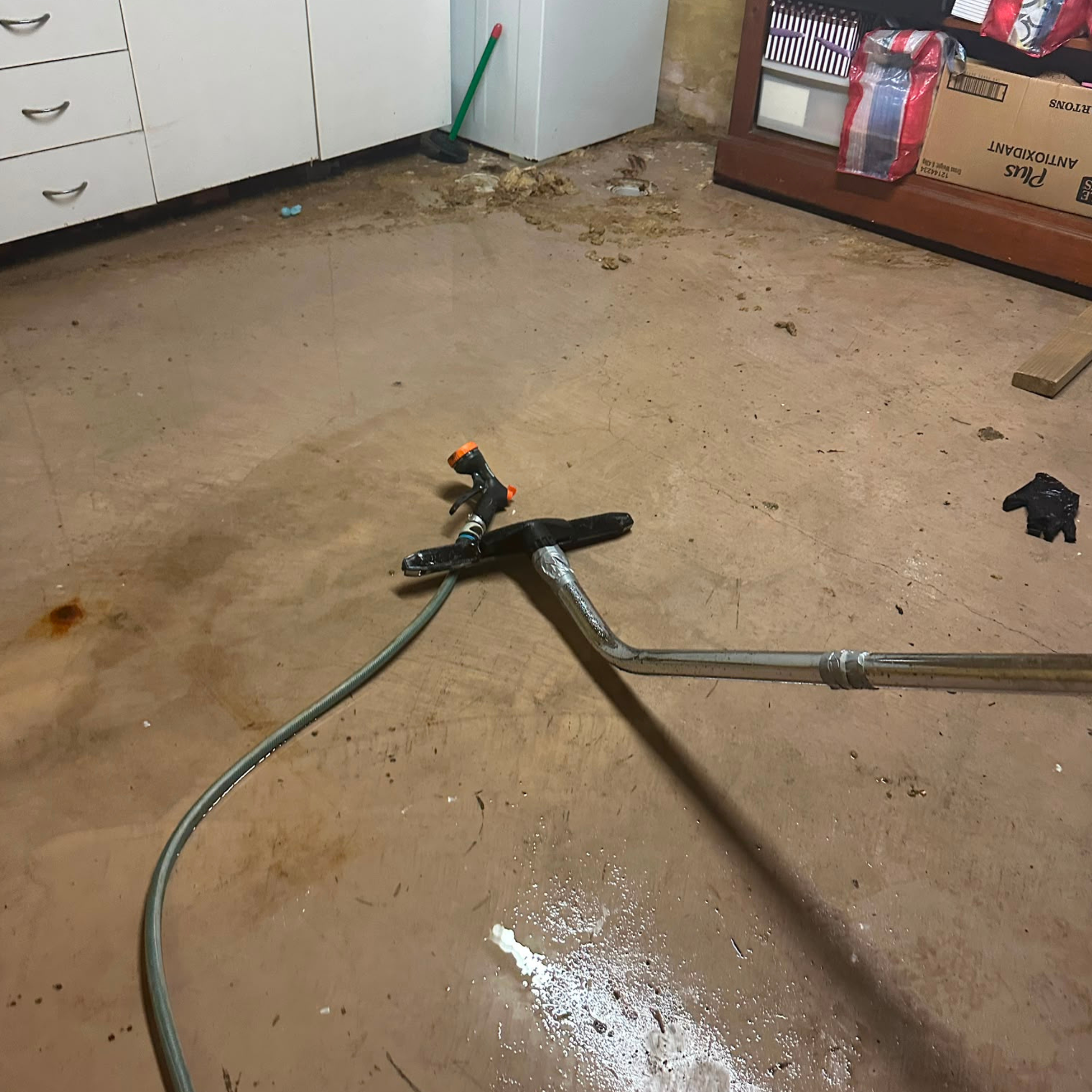 Wet vacuuming the garage slab after a sewer overflow in Cronulla, NSW