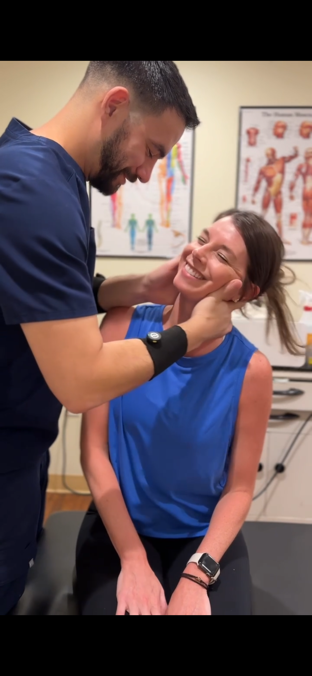 Dr. Bruna performing a cervical adjustment on a smiling patient