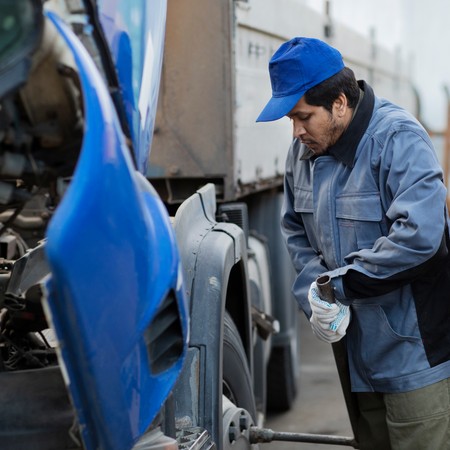 Technician performing mobile truck maintenance on commercial vehicle