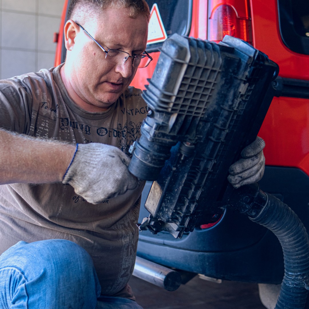 Diesel technician performing maintenance on commercial truck engine