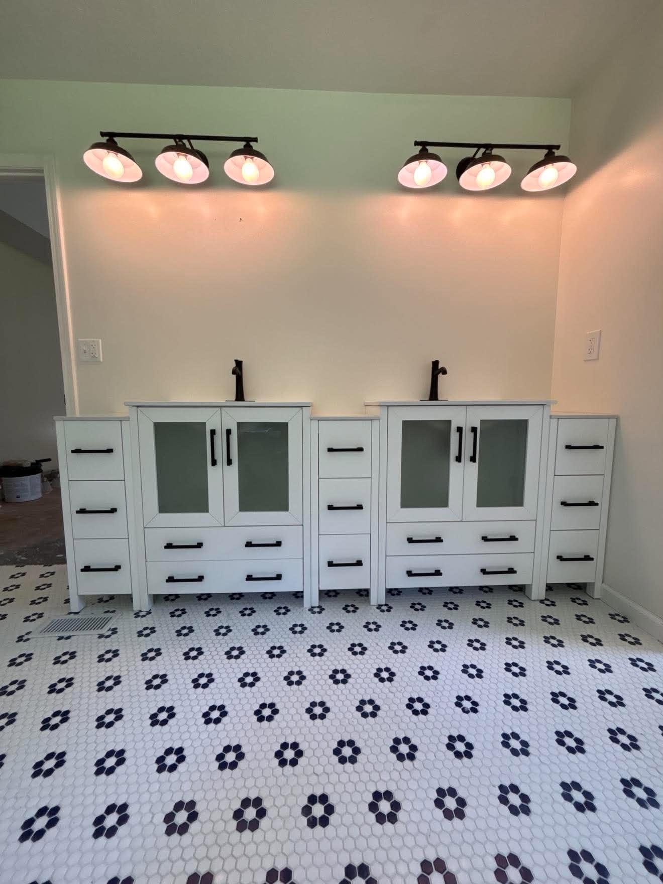 Bathroom remodel with new flooring, a new vanity, and updated light fixtures