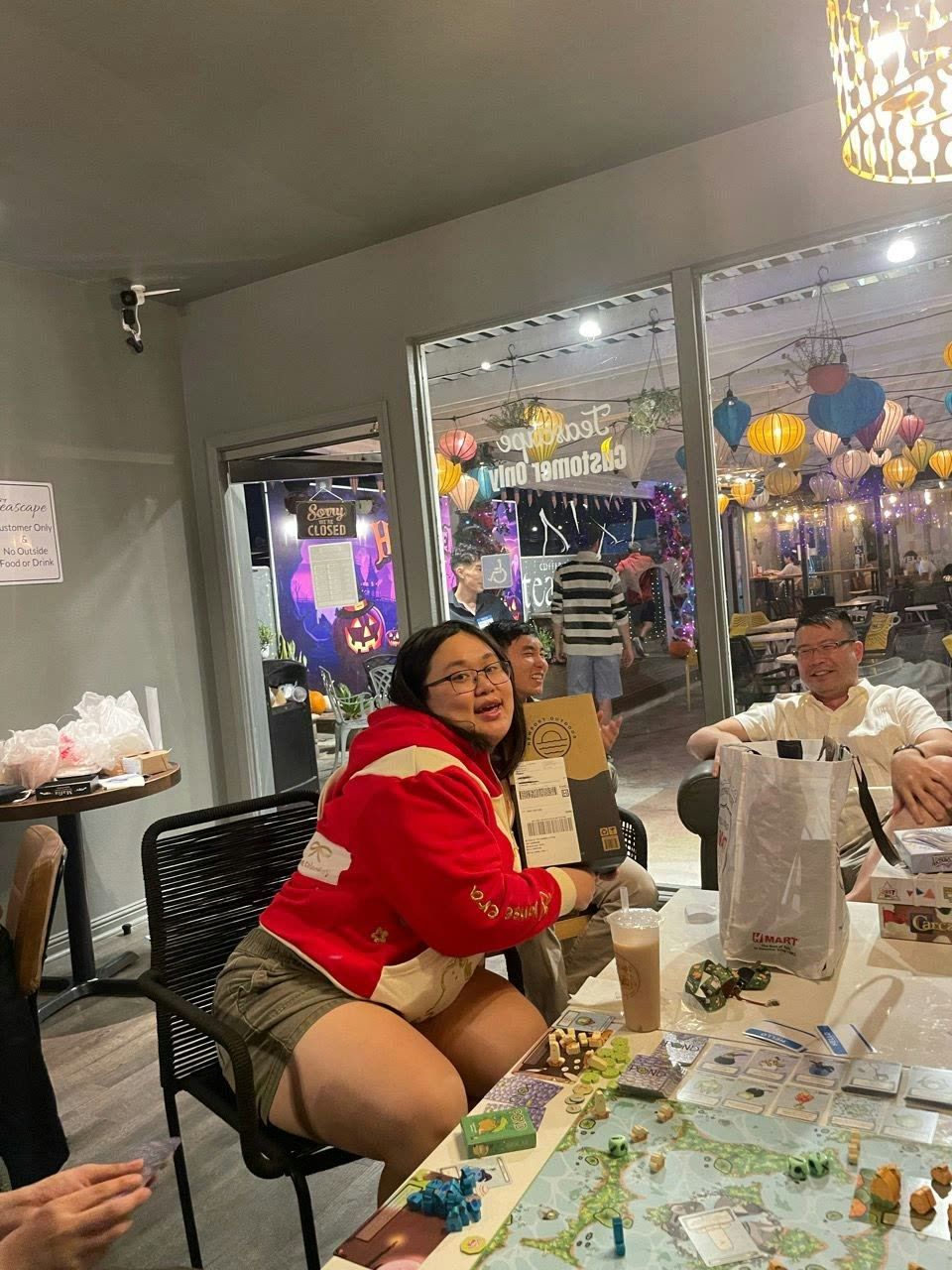 A smiling member chatting with friends around a game-night table