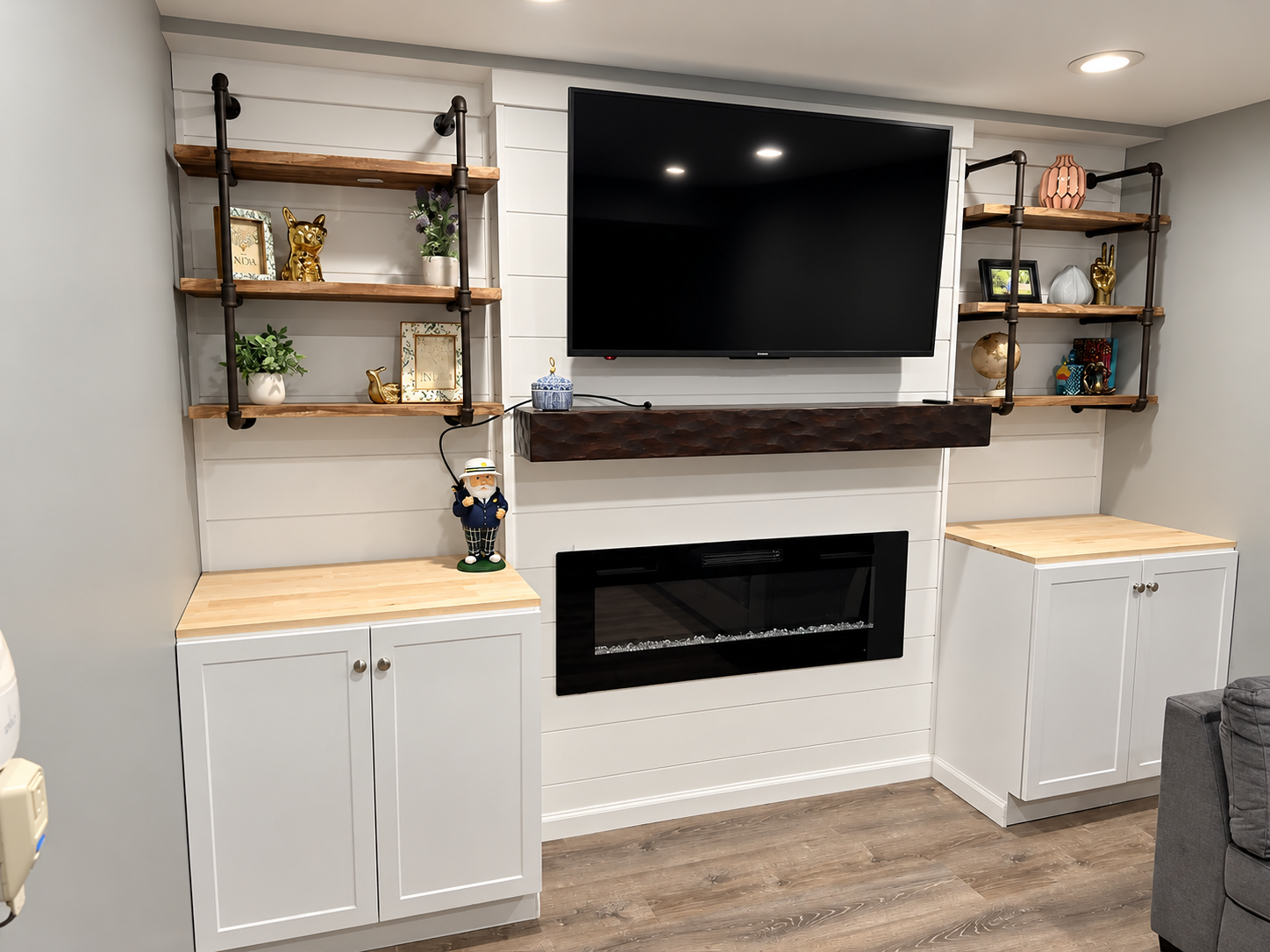 Custom basement media wall with electric fireplace and built-in cabinets by KingStruction