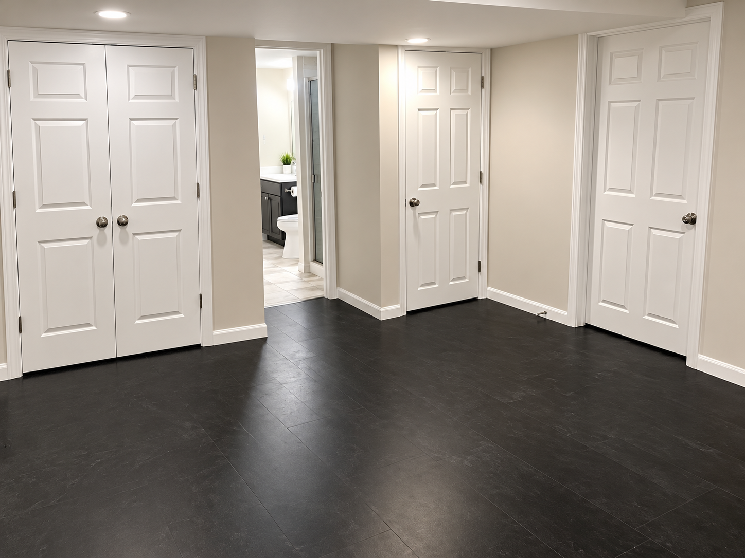 Finished basement hallway with bathroom and storage closets by KingStruction