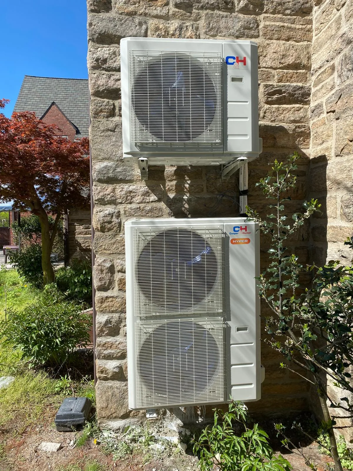 Two Cooper and Hunter mini split condensers installed on a stone home in Monmouth County, NJ