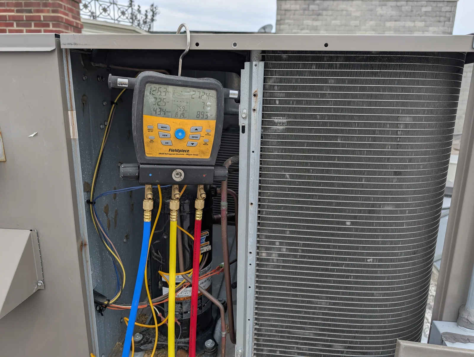 Digital manifold gauges reading refrigerant charge on an AC in Freehold, NJ