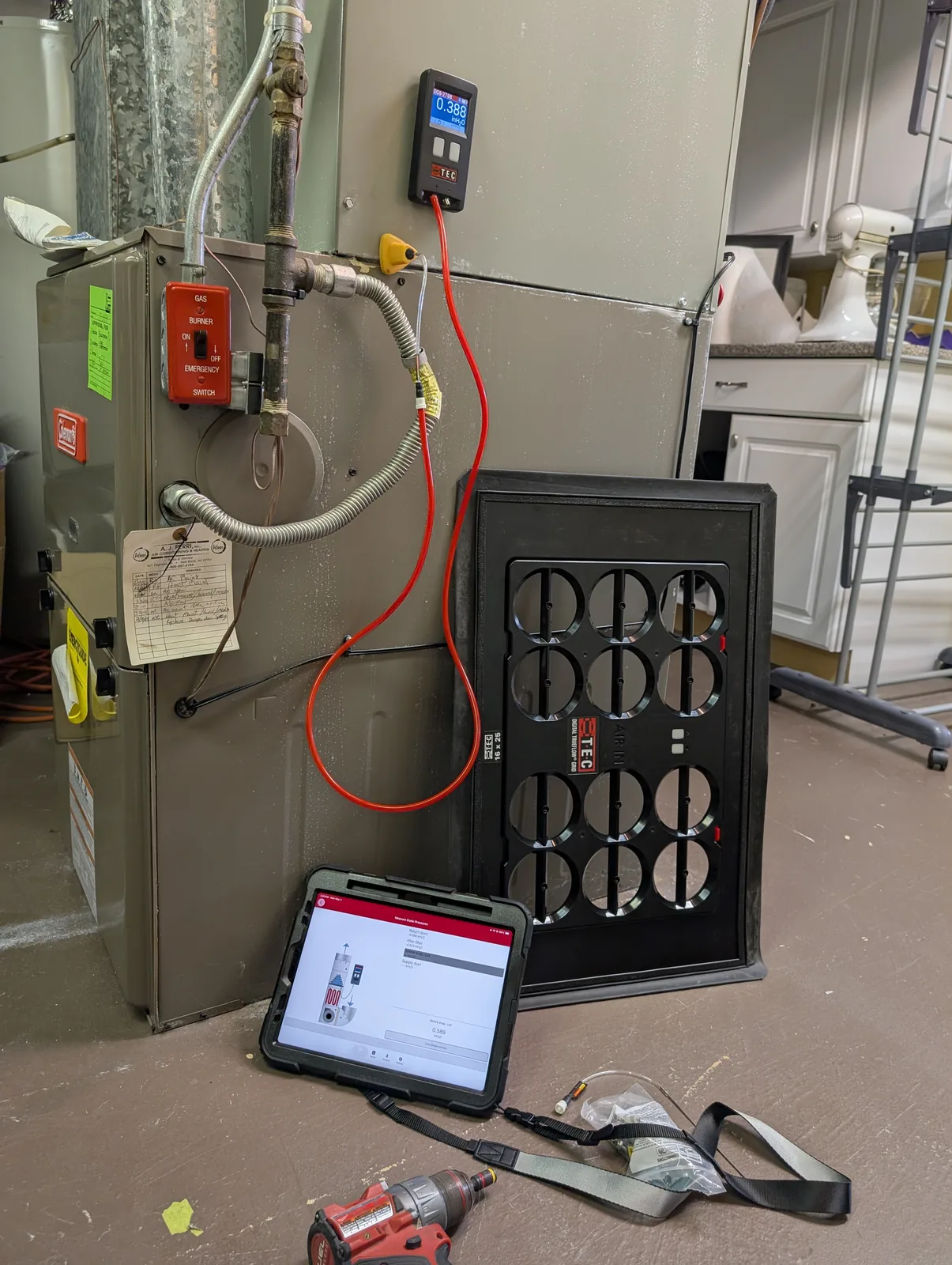 Digital manometer and tablet measuring static pressure on a furnace in Freehold, NJ