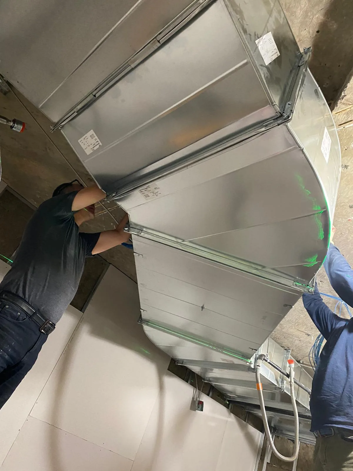 Novus technicians installing sheet metal ductwork in a Monmouth County, NJ basement