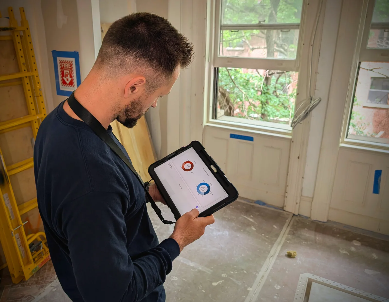Alexander Medvedev reviewing Manual J load calculations on a tablet at a Freehold, NJ jobsite
