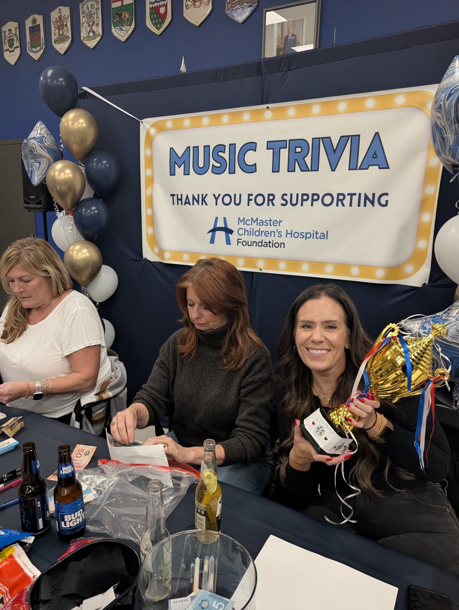 Friends gathered around a table playing music trivia together