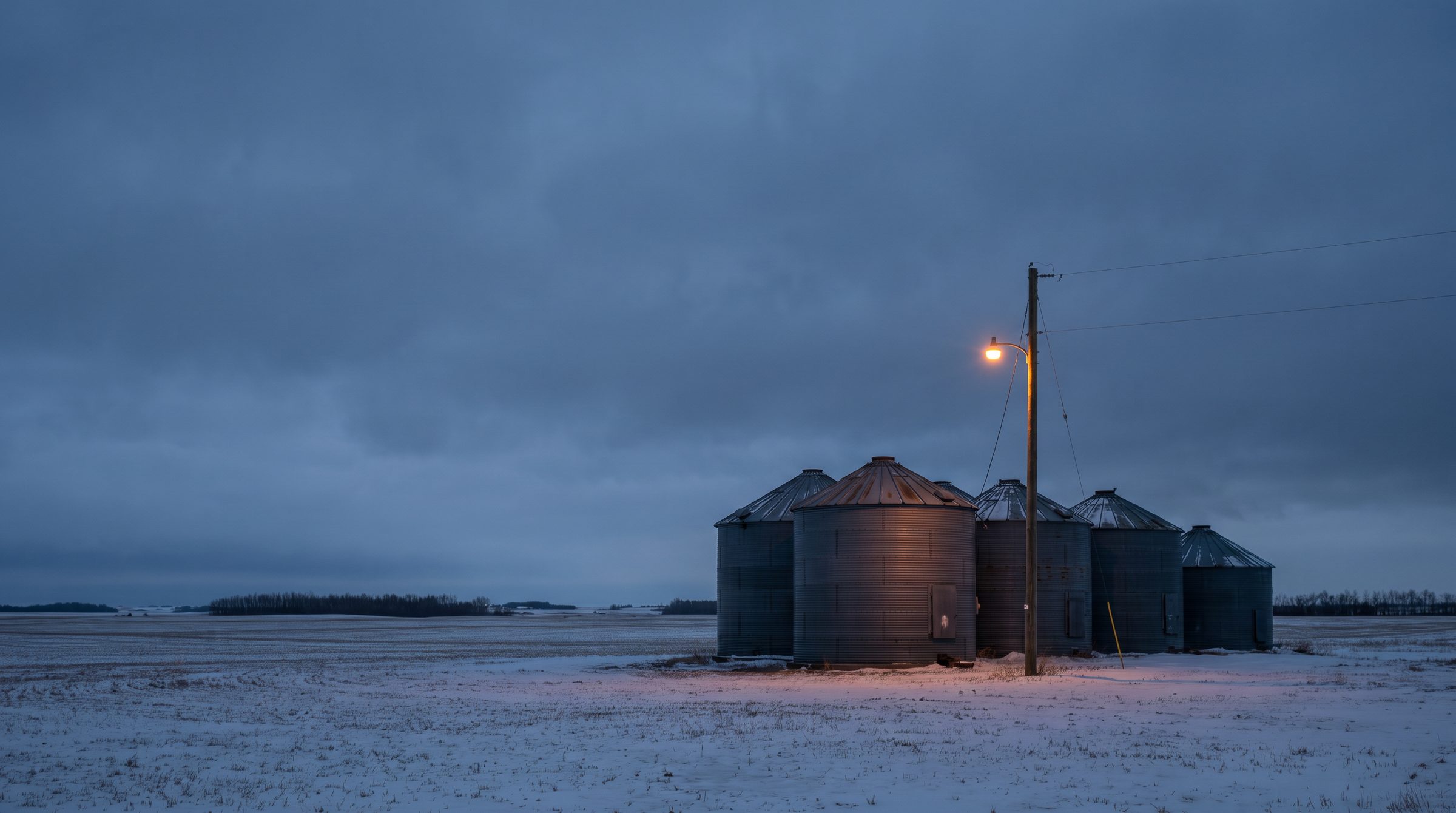 Grain bins and yard lights in the Falher and Smoky River area at dusk