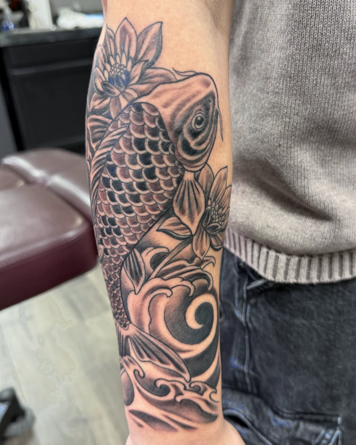 Color koi fish and lotus flower tattoo by Nicole Miller in Missoula Montana