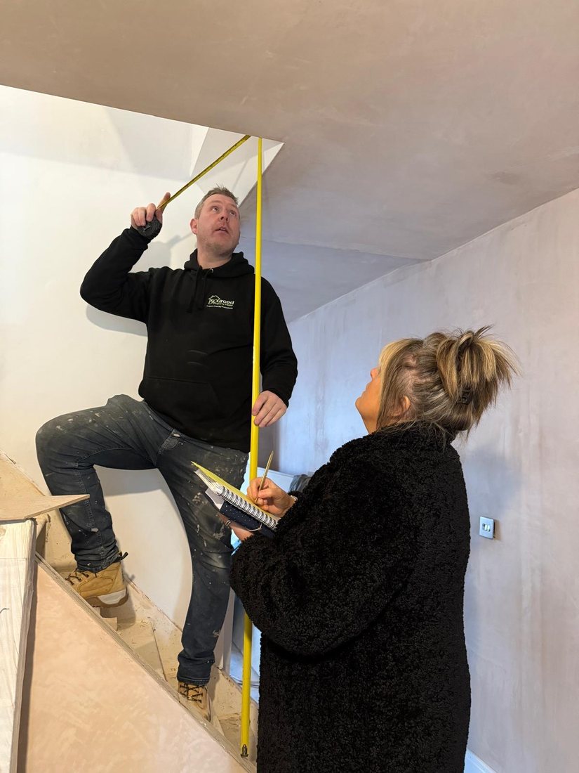 Darren and Vanessa measuring up a staircase during a refurbishment