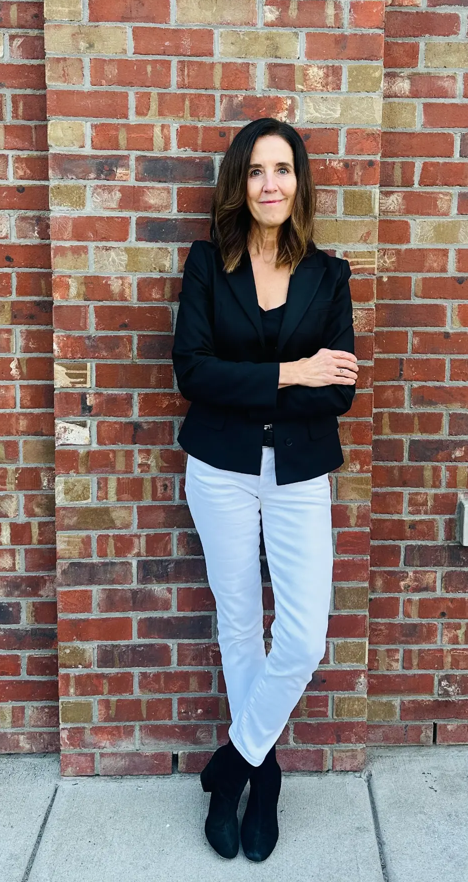 Founder standing by brick wall