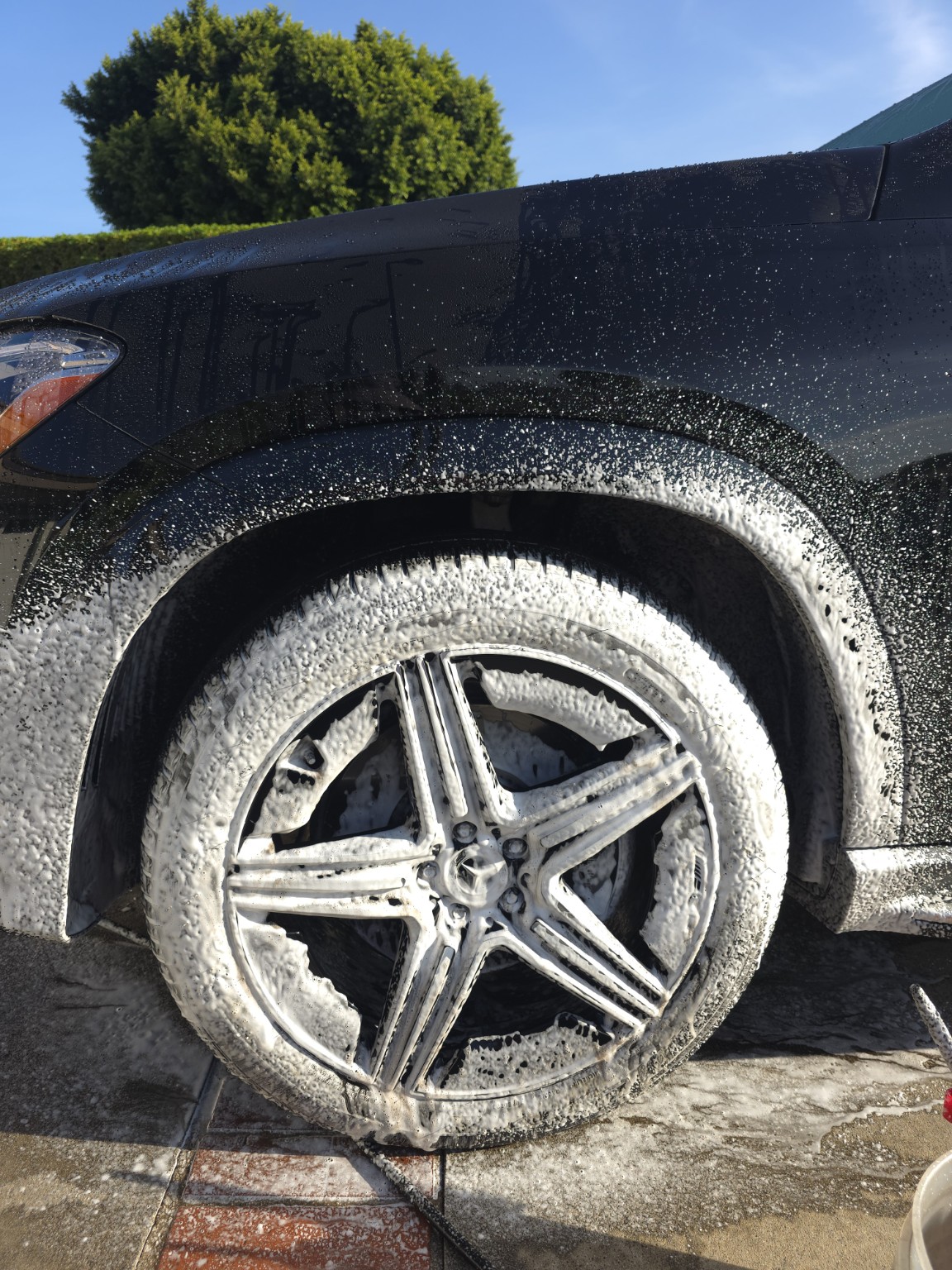 Mercedes-Benz GLE Coupe wheel and tire covered with cleaning foam during maintenance