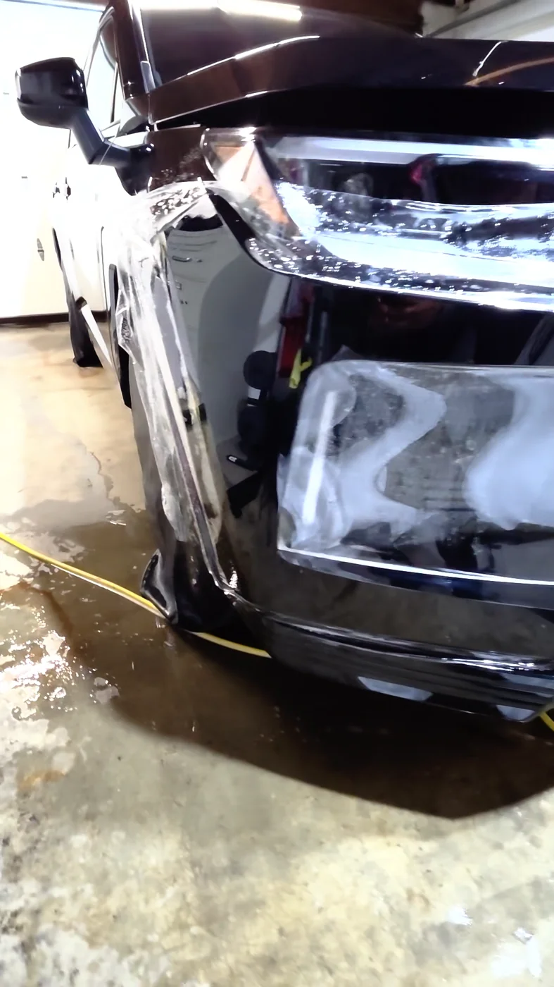 Clear paint protection film being fitted around the Toyota RAV4 front bumper beside the headlight.