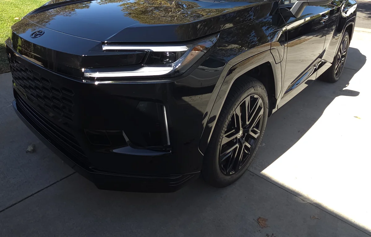 Front bumper, hood and front wheel of the dark blue Toyota RAV4 after full-body PPF installation.