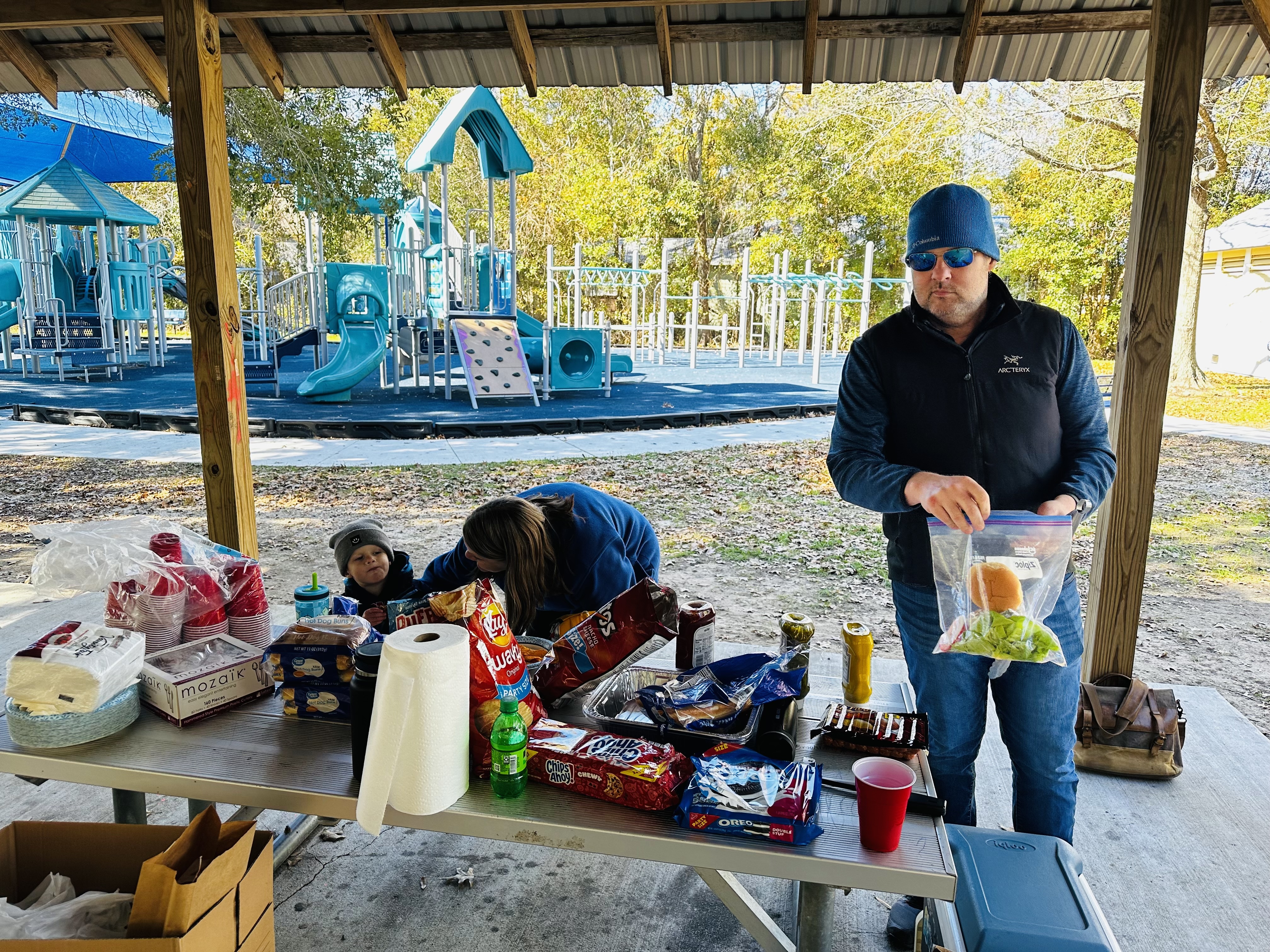 Volunteers sharing food together at a community gathering in a park