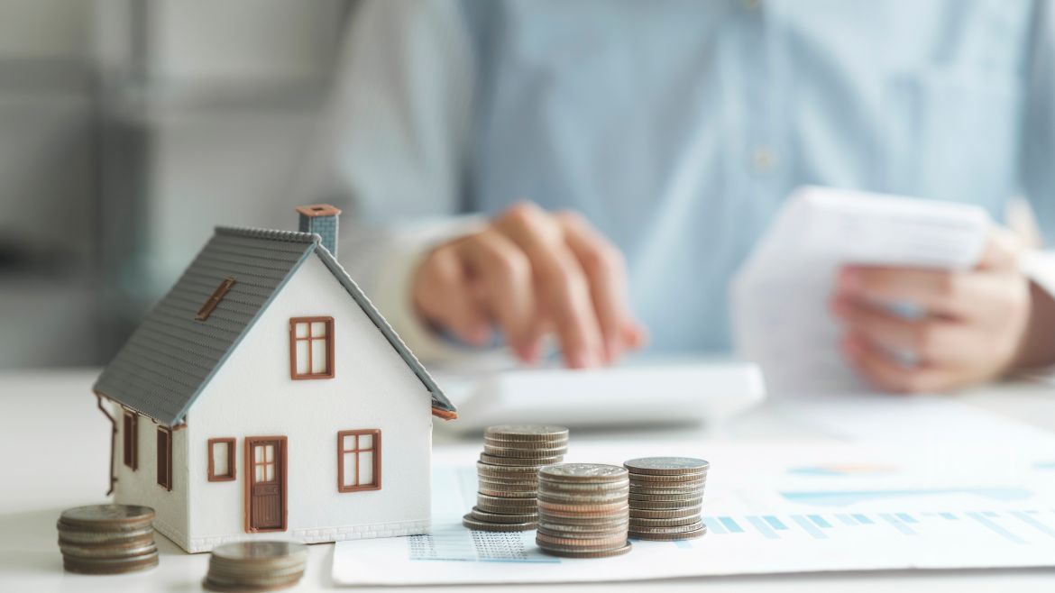 Couple planning home purchase with laptop and notebooks discussing priorities and house hunting strategy