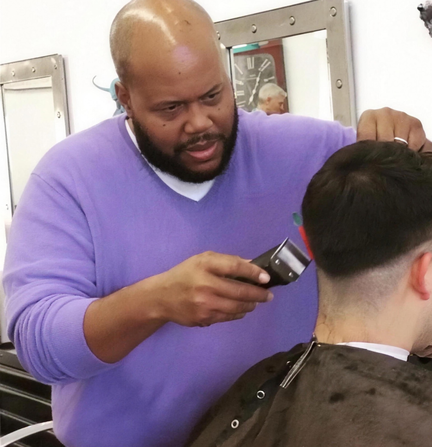 Gerard cutting hair in his shop