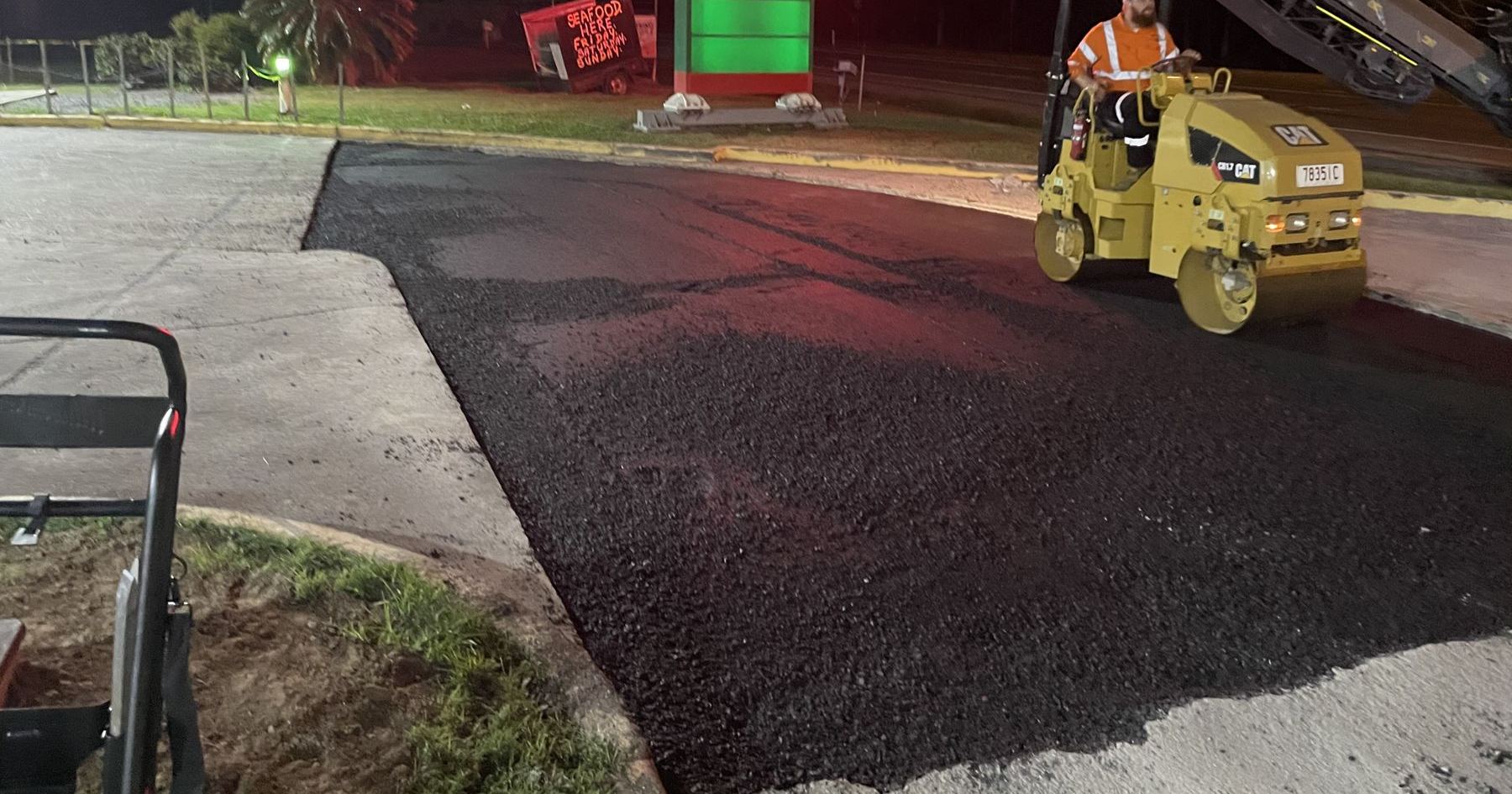 Roller compacting hot mix asphalt on a Gold Coast repair