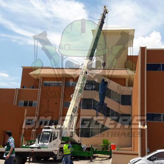 Montaje de equipo industrial con grúa en edificio en construcción