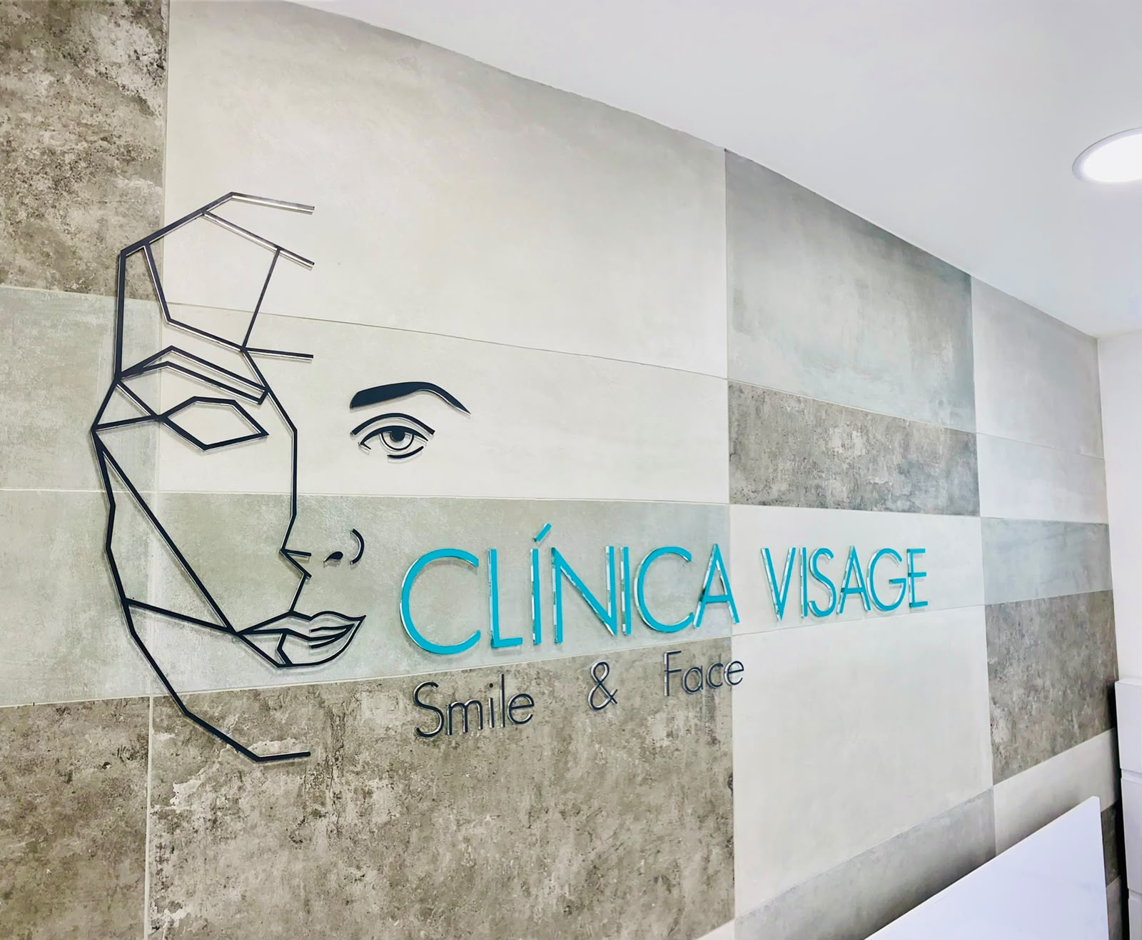 Muro con el logo de Clínica Visage en la recepción