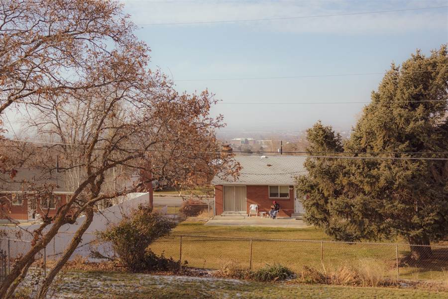 A brick ranch home on a hillside overlooking the valley.