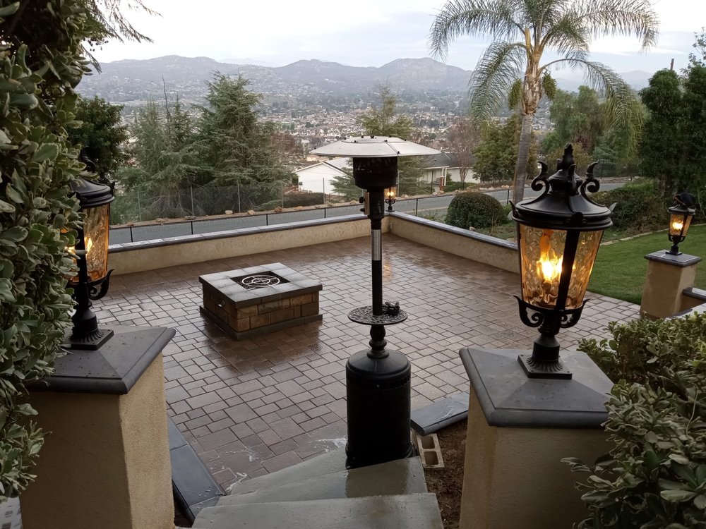 Finished paver patio with built-in fire pit and hillside view