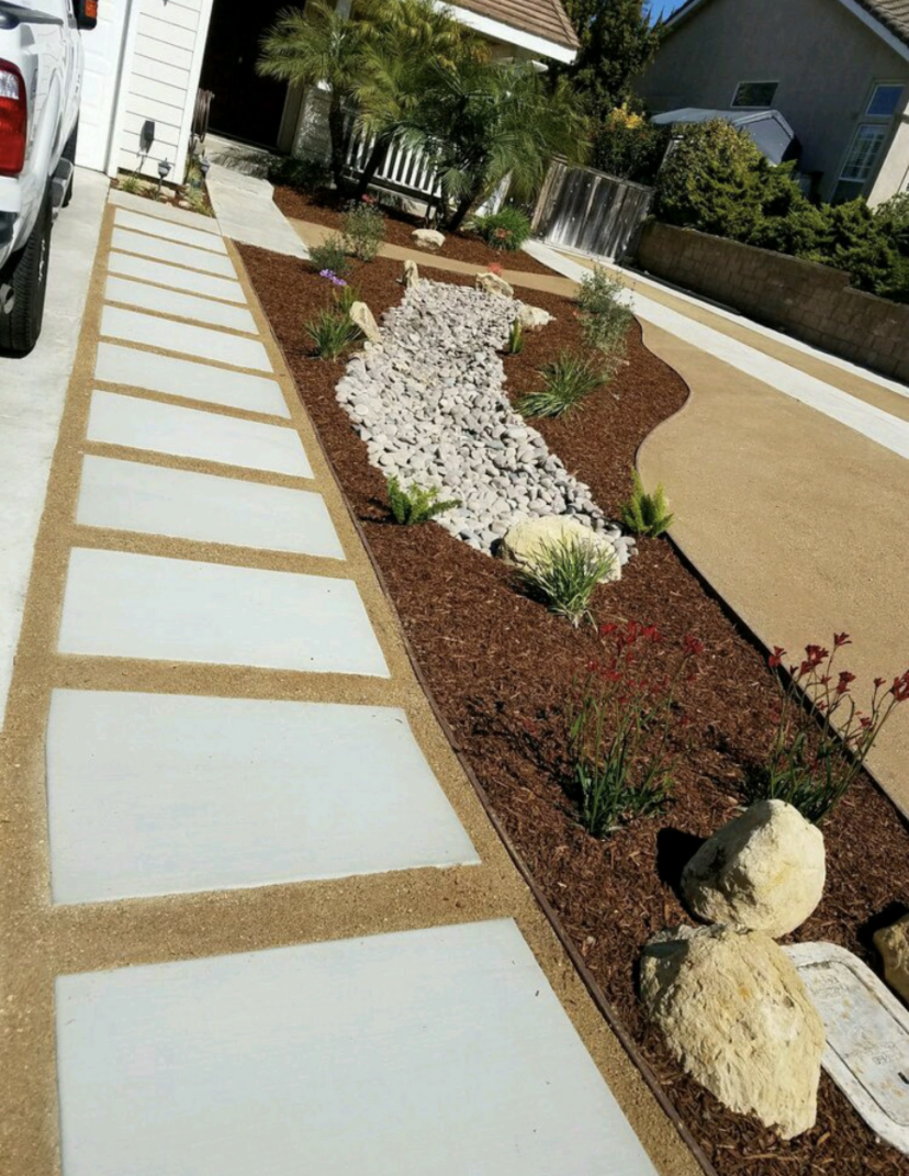 Front yard dry river rock bed with concrete stepping-stone walkway and drought-tolerant plantings