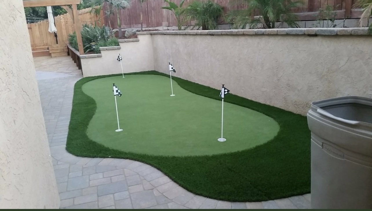 Curved synthetic putting green with stone patio surround