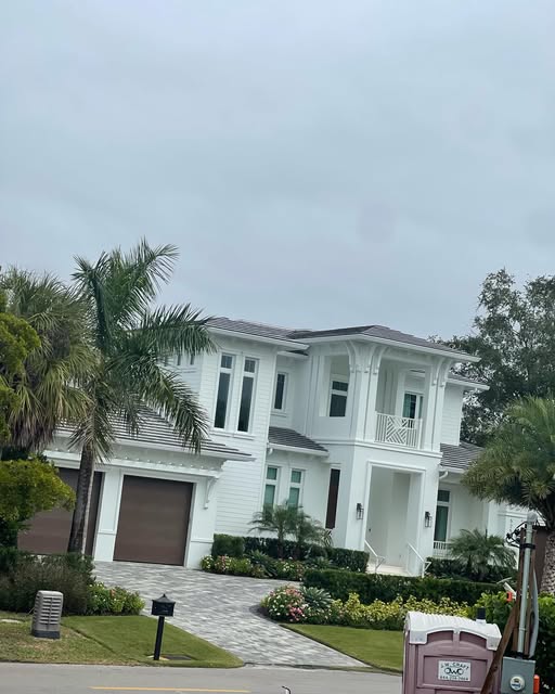 Finished two-story white home with palms