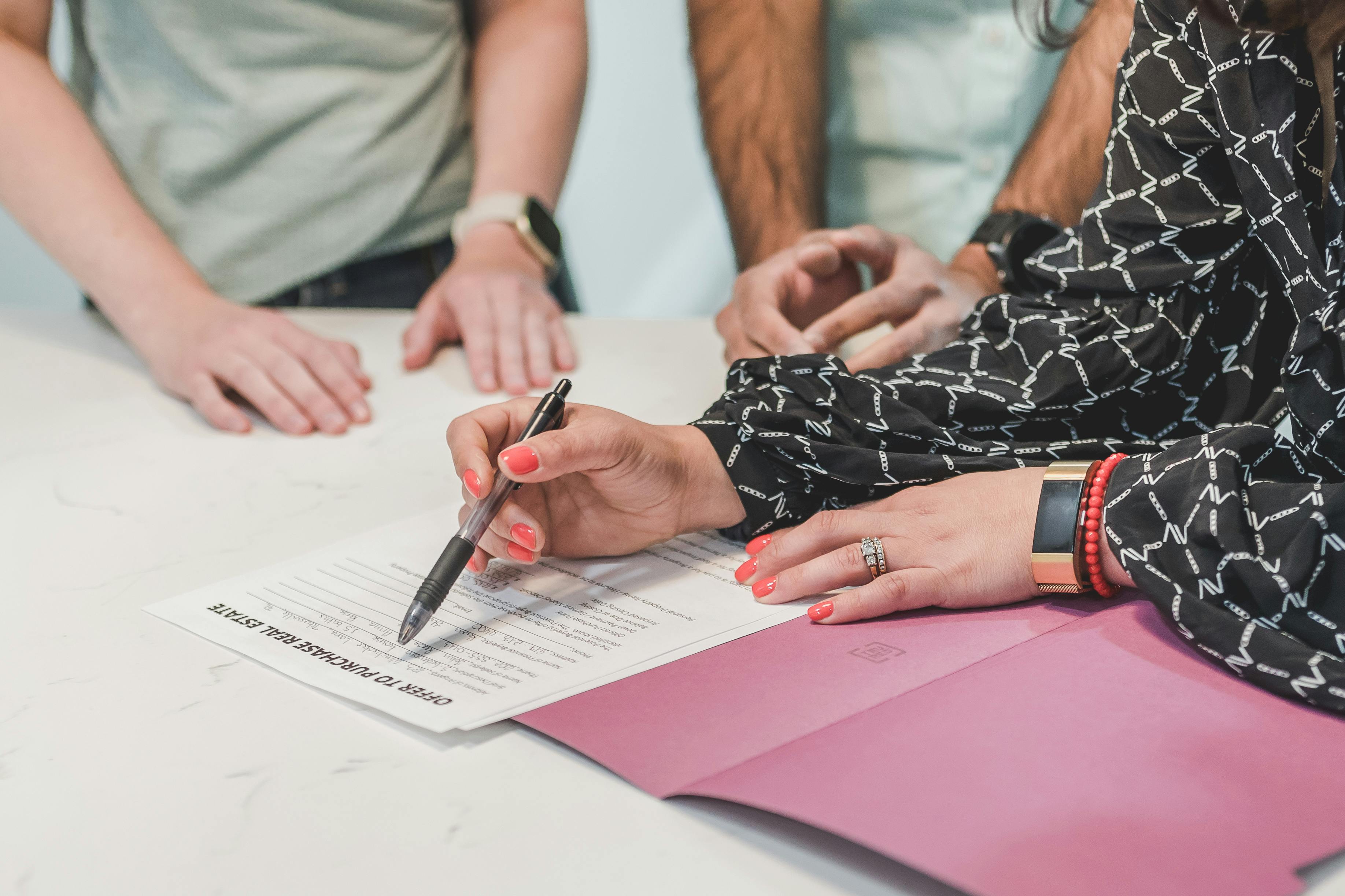 Close-up of a real estate agents nc together with the couple signing a contract for home purchase.jpg Close-up of a real estate agents nc together with the couple signing a contract for home purchase.jpg