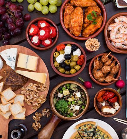 Overhead tapas spread with cheese, olives, bread, croquettes, and salads Overhead tapas spread with cheese, olives, bread, croquettes, and salads